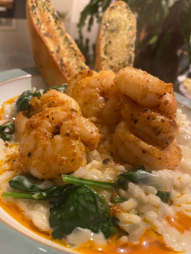 Cajun prawns rested on a creamy spinach risotto by Siobhán Devereux Doyle